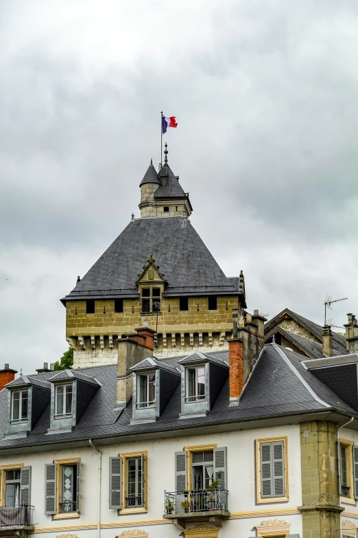 an old brick building with many windows and a flag on the roof