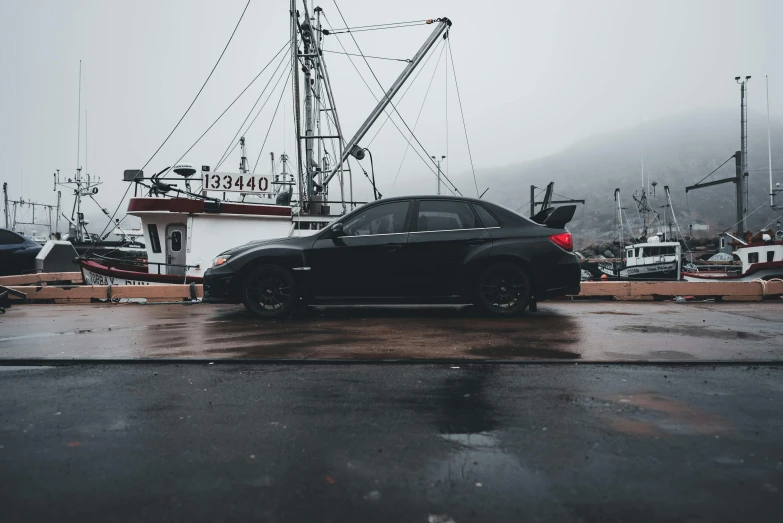 black sport utility vehicle sitting on a wet parking lot