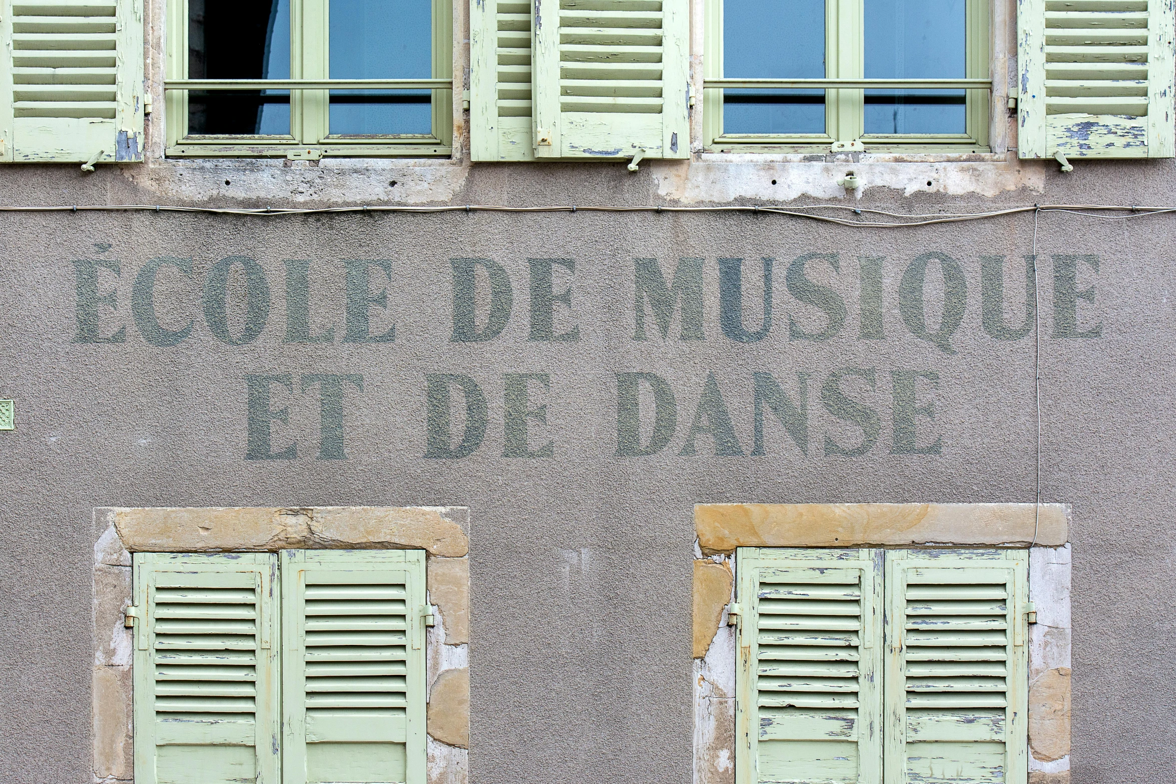 a close up of two windows and a wall with shutters