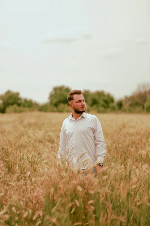 a man standing in a field looking off to his left