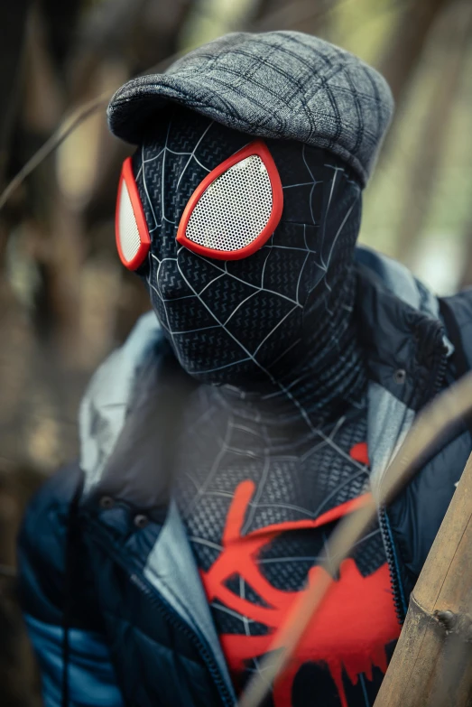 a person wearing black mask, red eye patches and a hat