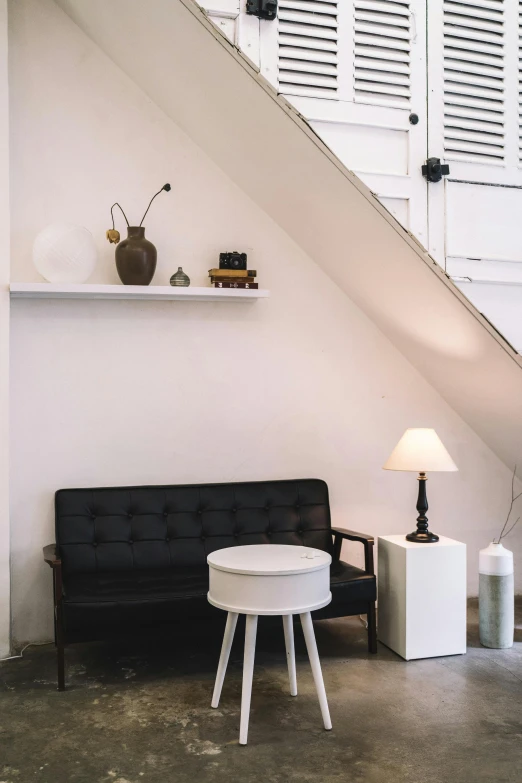 a couch and some tables under a stair case