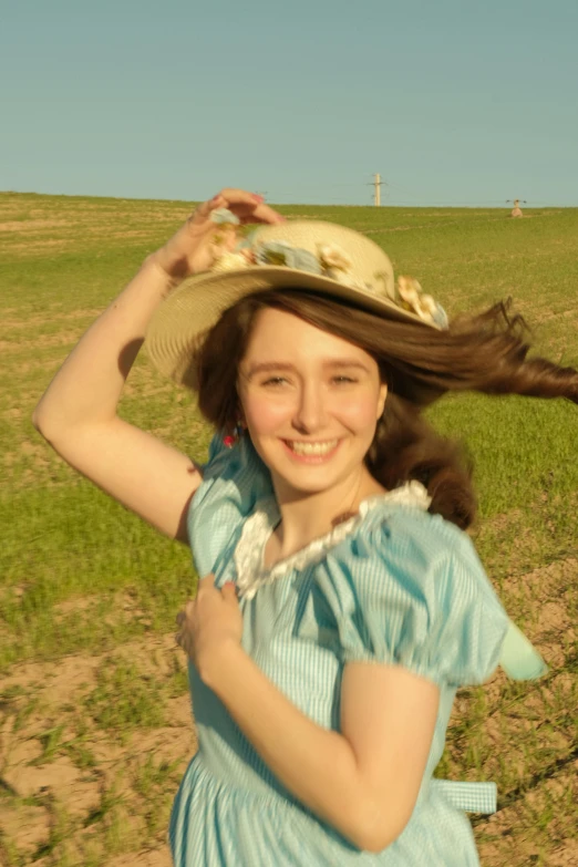  wearing dress with large straw hat on her head