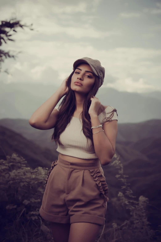 a young woman standing next to a mountain range