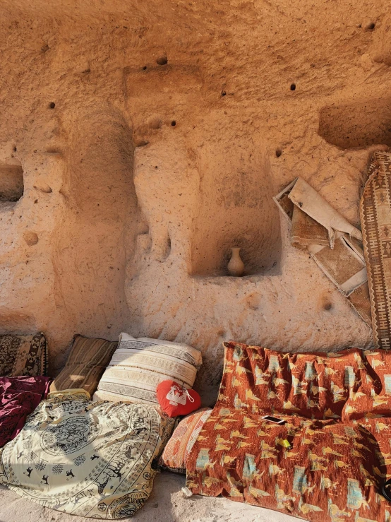 various oriental cushions and rugs laid out outside a desert structure