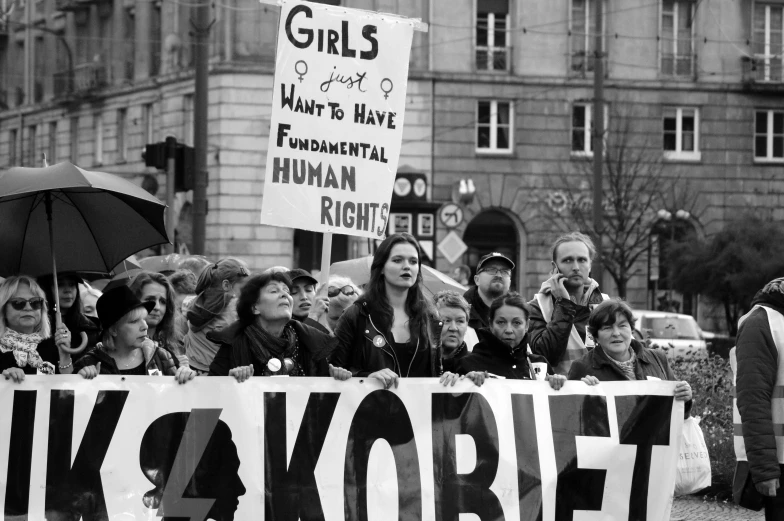 women holding protest signs with their names and hands