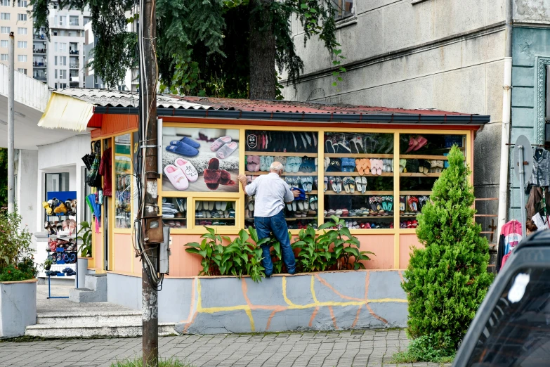 a man leans on the side of a colorful book stand