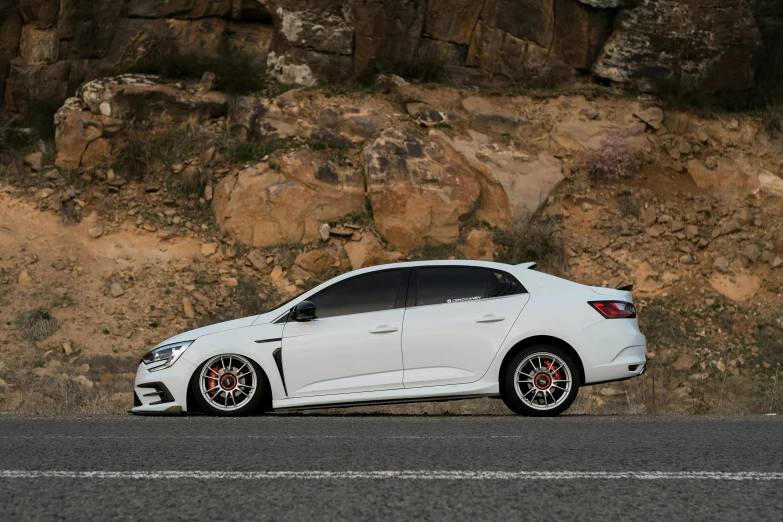 a white car parked near a steep terrain