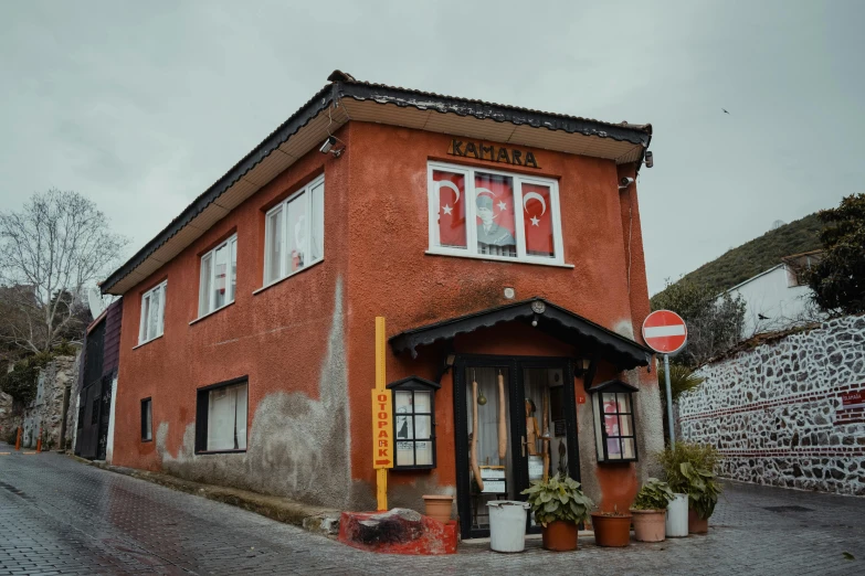 an orange building with red walls and two large windows