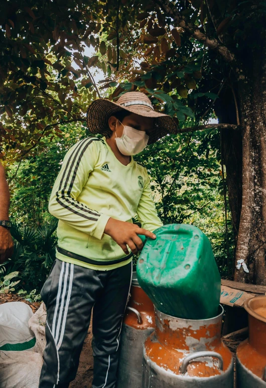 a little boy wearing a face mask and covering his mouth