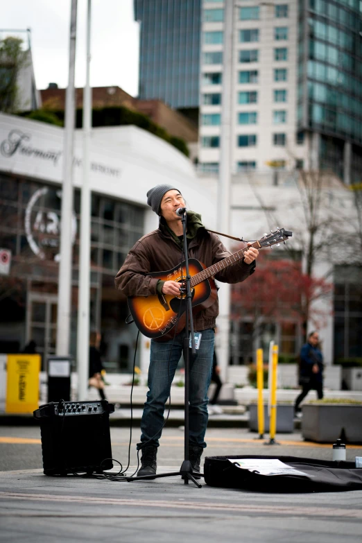 the man is playing a song while standing by a microphone