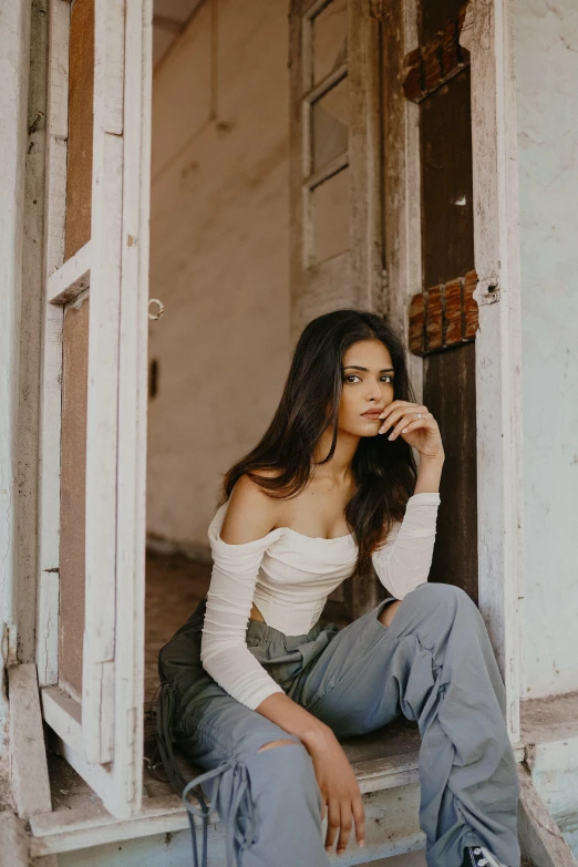 a girl in denim jeans sitting on the window sill