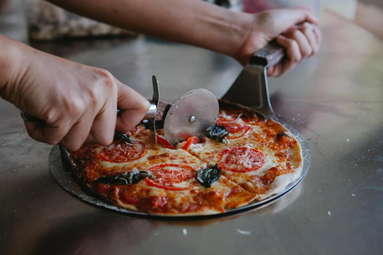 a close up of a pizza being cut with a knife and fork