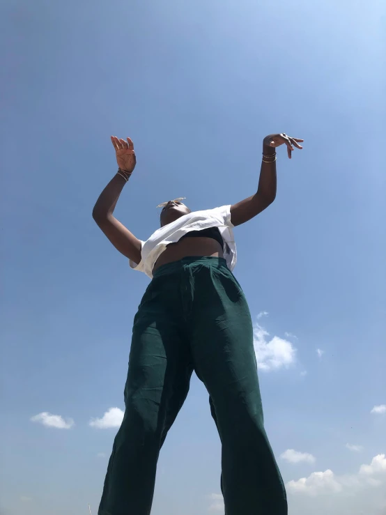 a woman looking up at the sky flying a kite