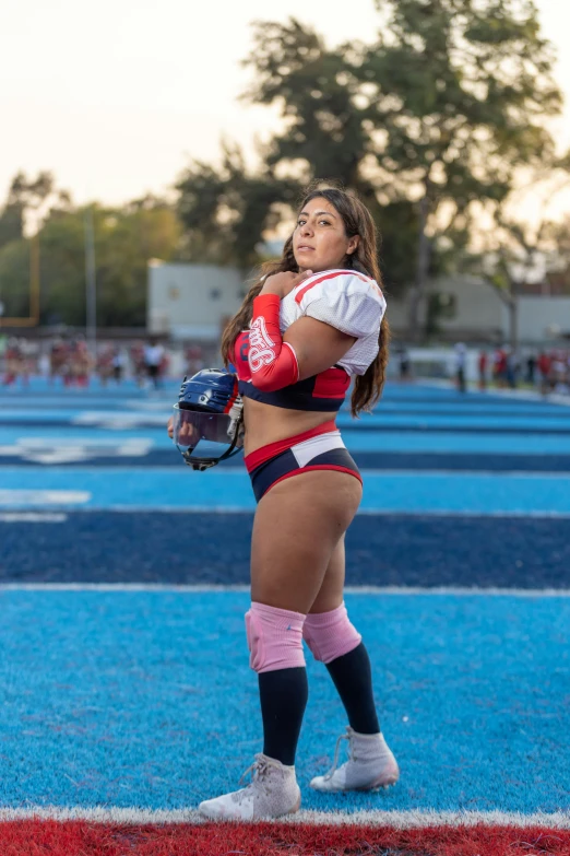 a woman with a baseball glove and helmet standing on the field