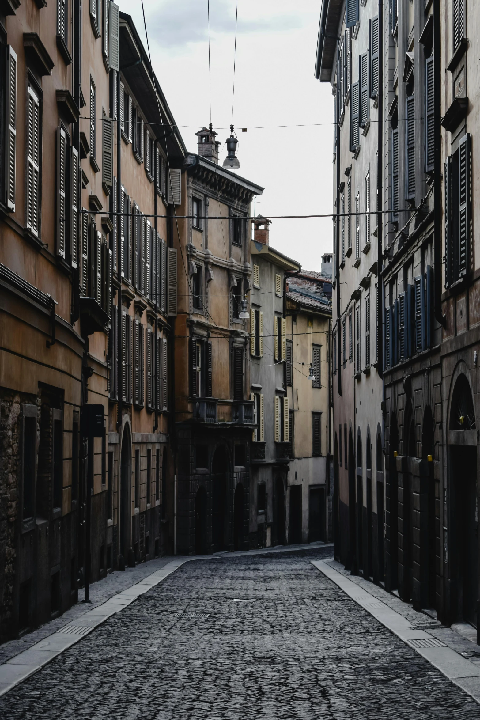 a cobblestone street is lined with old buildings