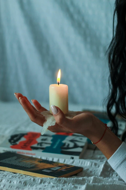 a woman is holding a candle in her hand