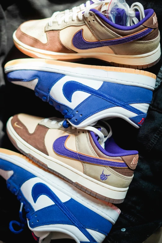 three sneakers stacked together with blue and orange accents