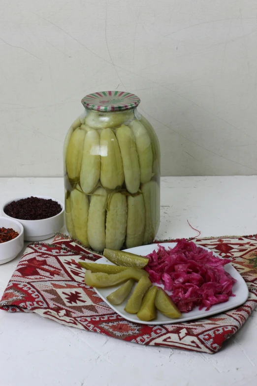 a table topped with a bottle of pickles and food