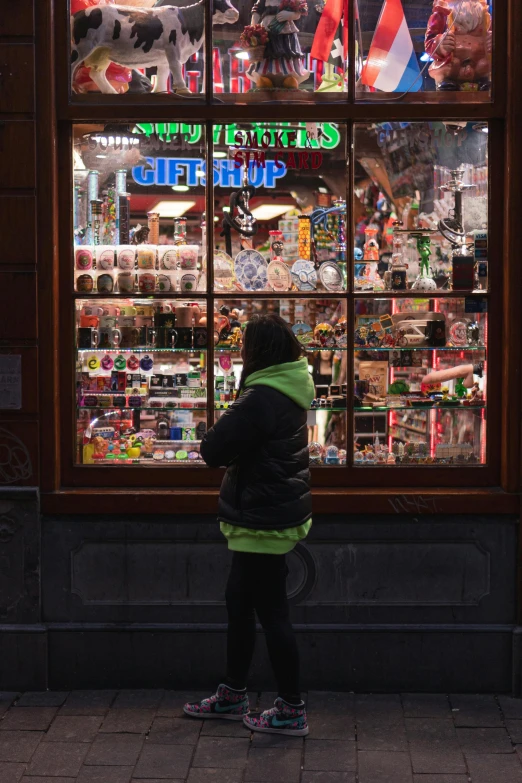 a girl standing outside the front of a store looking at souvenirs