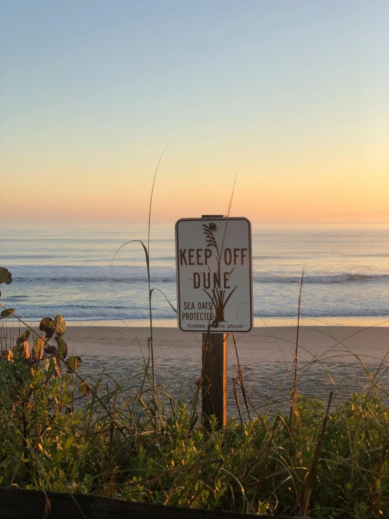 a sign warning people not to cut the grass near the water