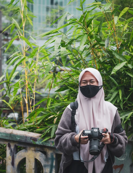 an old woman with a black face mask is taking a po with a camera