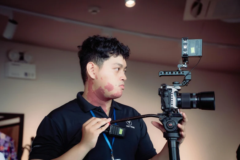 man holding camera near a video recorder recording a piece of paper