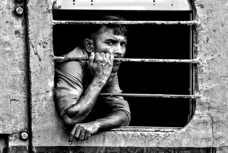 man looking out the window of a train car