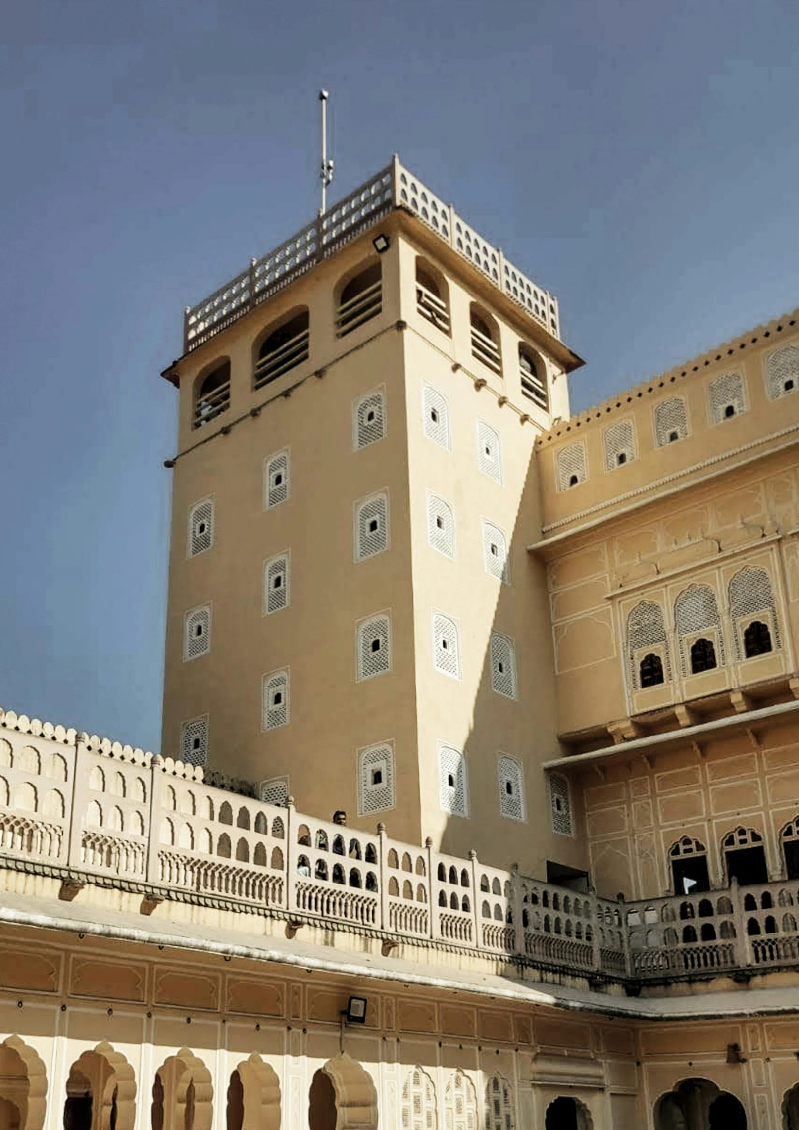 a tall yellow building with some windows and a fence