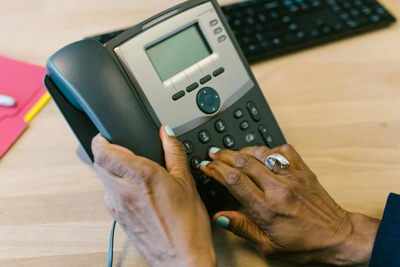 a woman using an old fashioned telephone on the desk