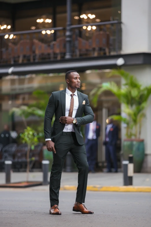 a man in green suit standing on a street