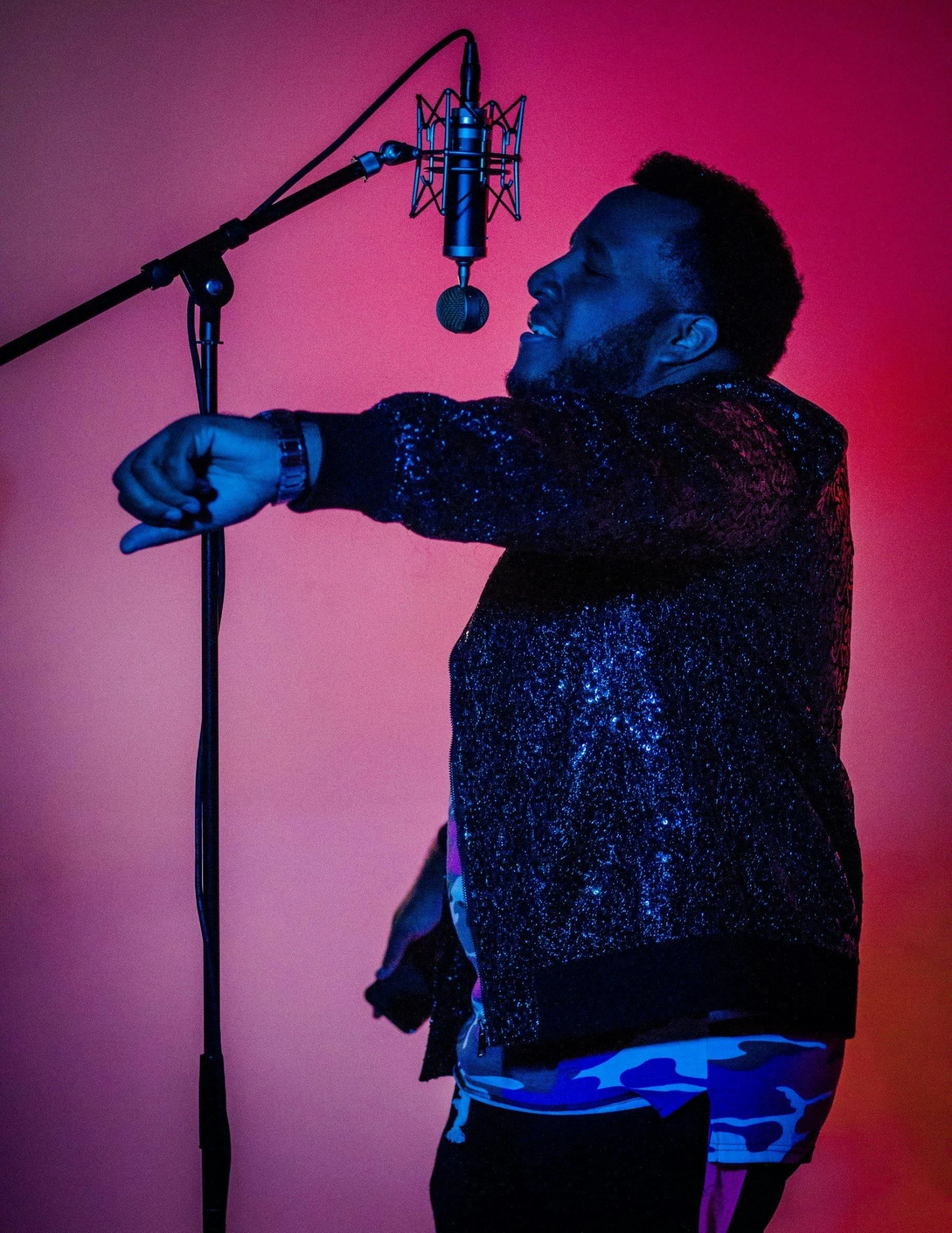 a man standing by a microphone with his arms out