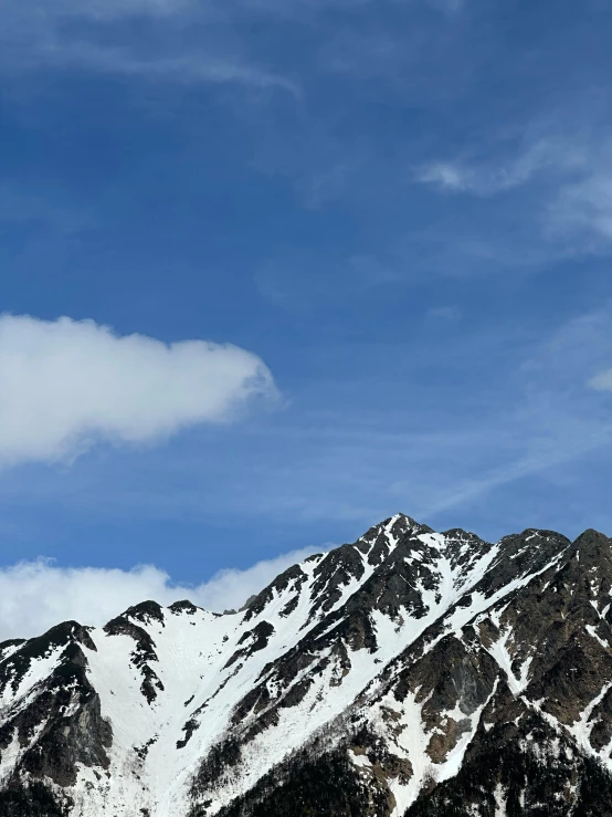 a plane flies high up in the air above snow covered mountains