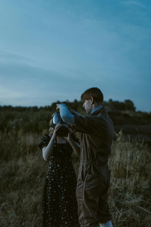 a man and woman look into each other eyes while holding a blue object