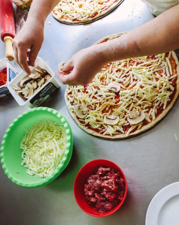 a person making a pizza on top of a table