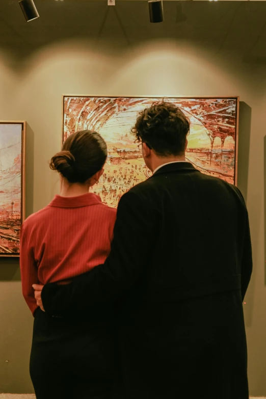 two people that are looking at art work