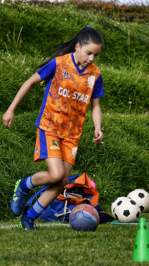 a female soccer player running with a soccer ball