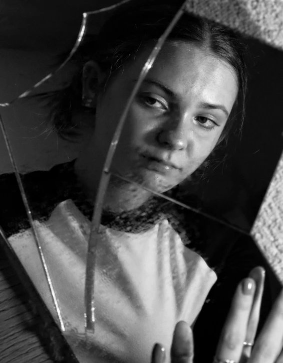 a black and white pograph of a girl wearing a tie holding an umbrella