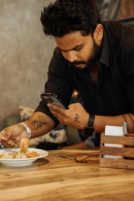 a man using his cell phone at a table