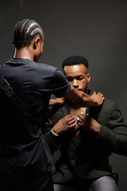 the black man is helping his colleague get ready