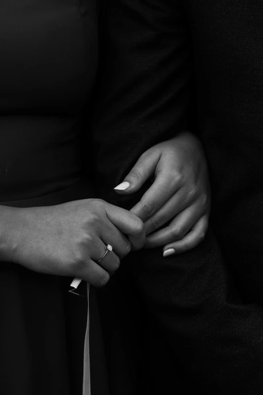 two people standing close together holding onto one another with their hands on the other