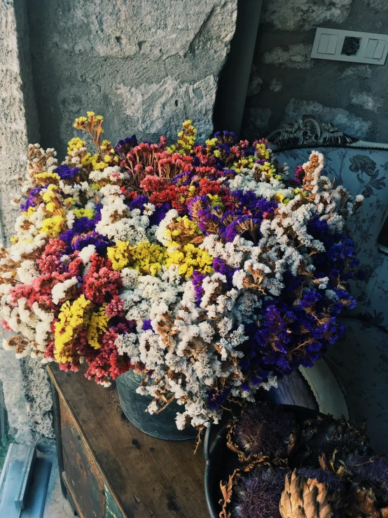 a wooden table holding a basket full of colorful flowers