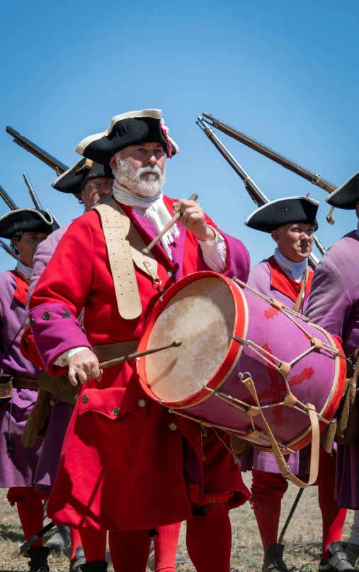 men dressed in red uniforms are holding instruments