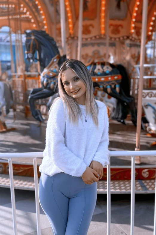 the woman is posing for a po on the carousel