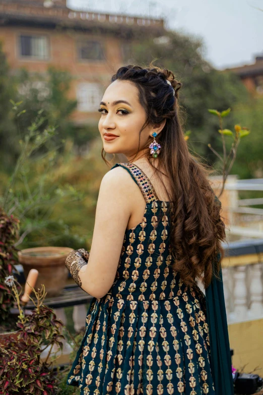 woman in ethnic dress standing in front of some plants