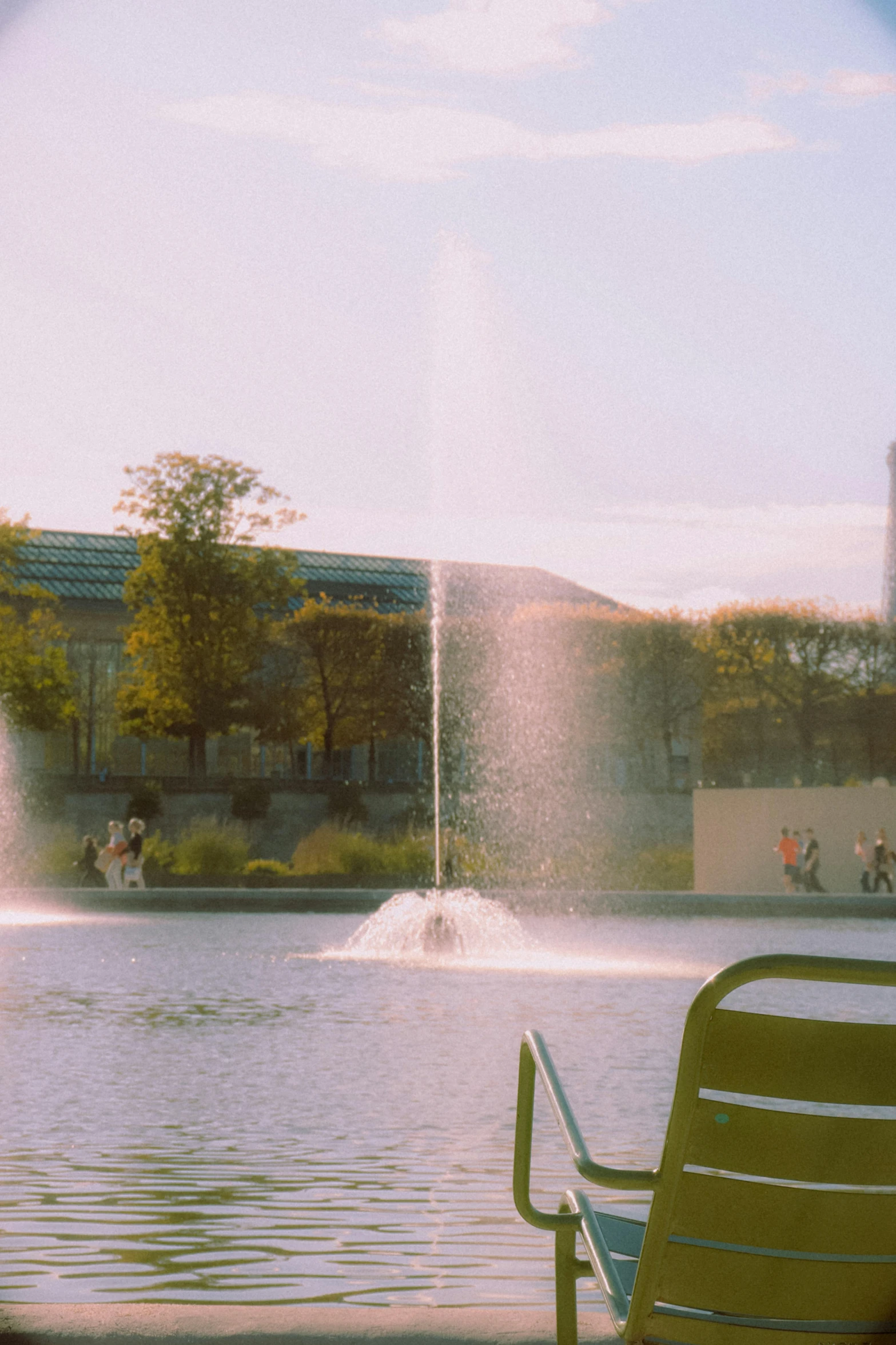 two chairs facing water fountain with a view of a building