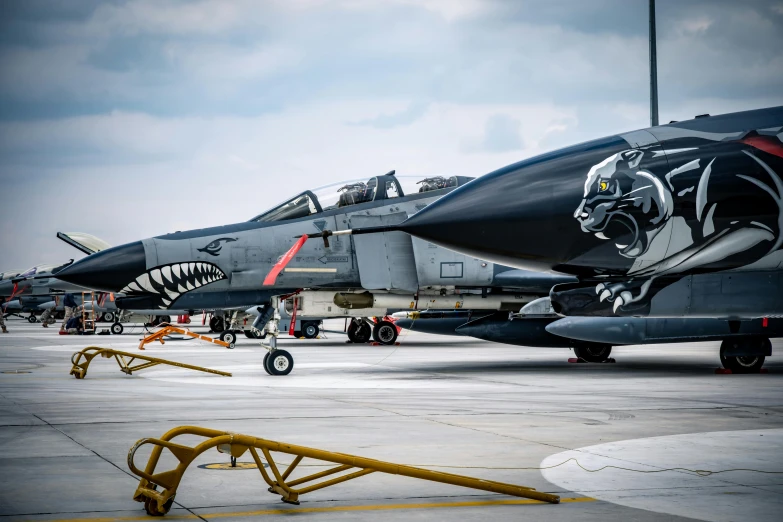 military planes are sitting on the tarmac as they sit