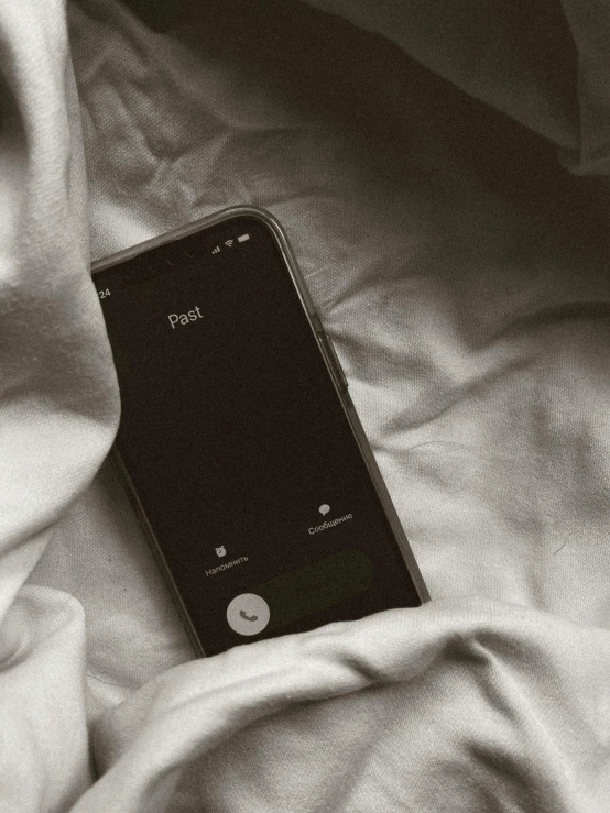 a cellphone is lying on a bed and some blankets