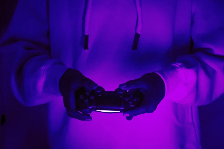 a man holding two game controllers in his hand