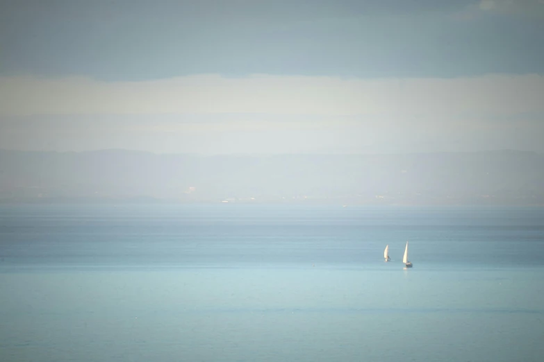 a sailboat with one catamaran on the horizon